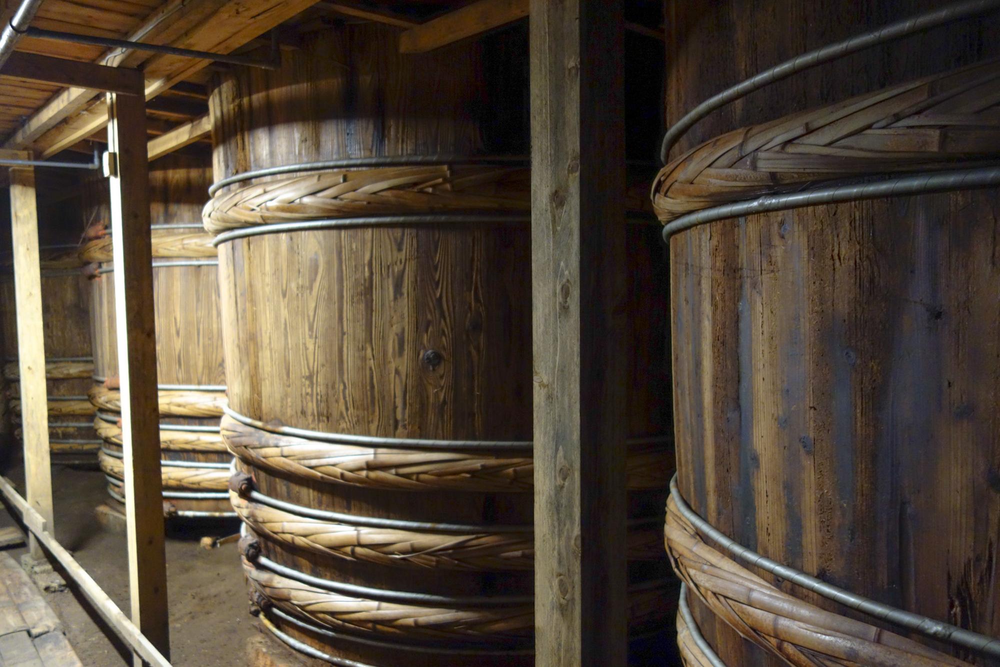 大人の背丈より高い杉桶。杉の木桶1本の中には、なんと約7トン半もの諸味（もろみ）が入っているというから驚きです。