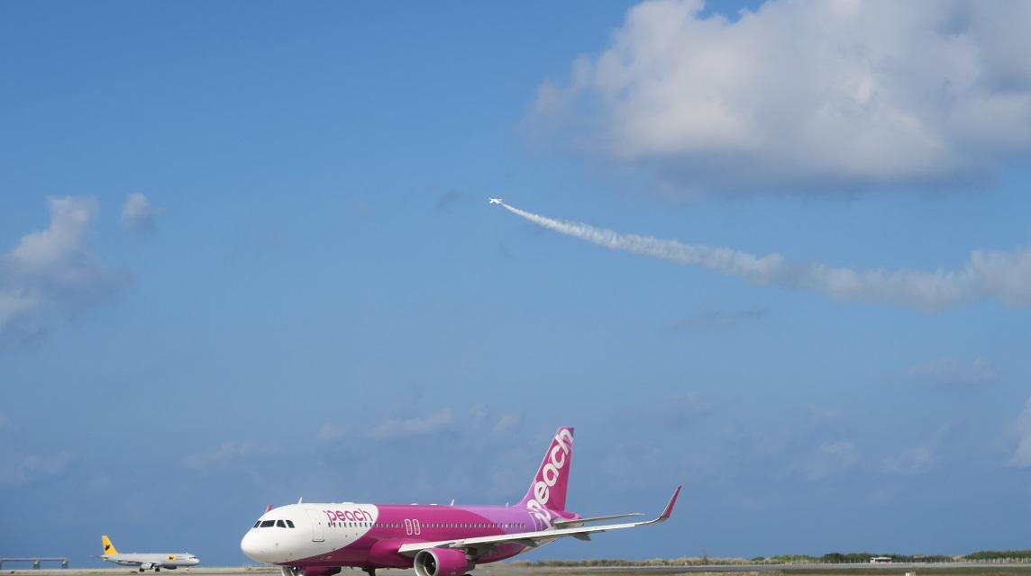 peachが滑走路を進んでいる上空をブルーインパルスが飛行しています